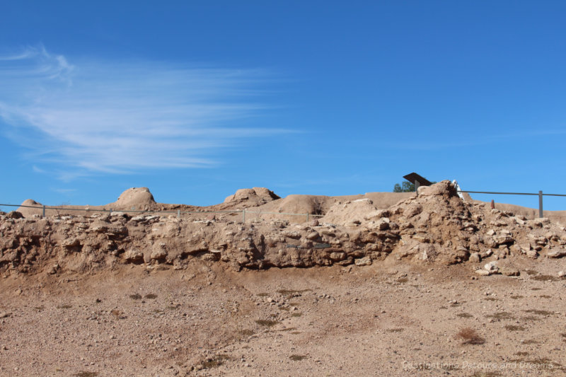 Sandy coloured mounds - Hohokam ruins - against a blue sky