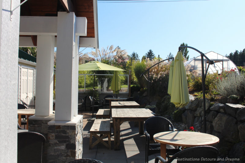 Wood tables and green shade umbrellas at the Roost patio