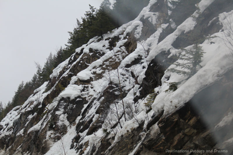 Snow partially covering rock slope of British Columbia mountain