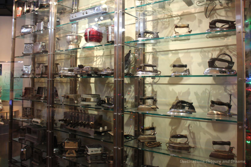 A display on many shelves in a glass case of small electrical appliances over the years