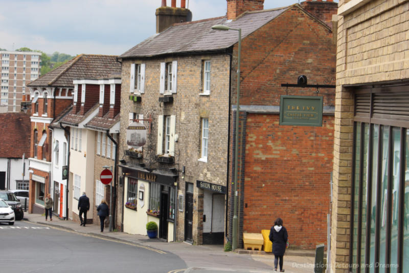 Street on a a hile with stone buildings on the left including The Keep pub