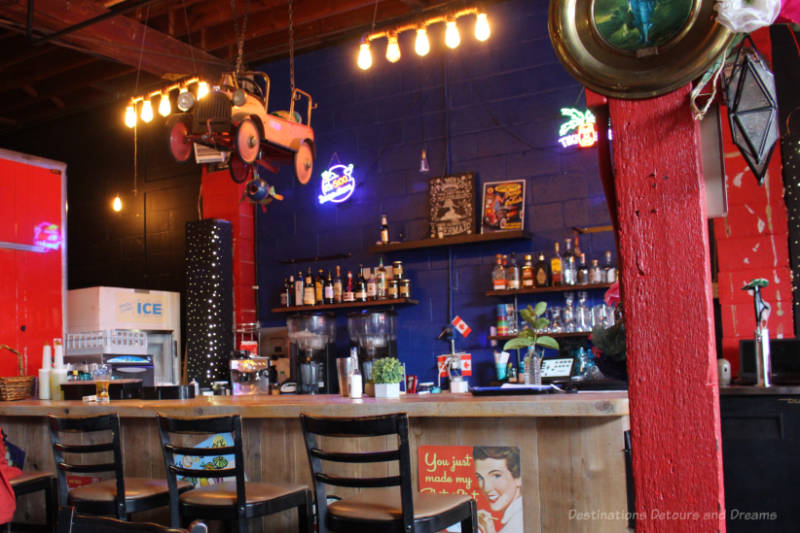 Bar area with colourful blue wall, red beams, and assorted curios at El Loco Taco on Salt Spring Island