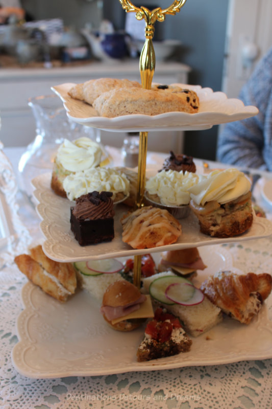 Three-tiered tray of finger sandwiches, sweets, and scones for afternoon tea at The Ol Farmhouse Cafe in Rosenort, Manitoba