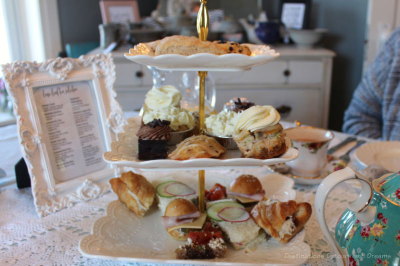 Three-tiered tray of finger sandwiches, sweets, and scones for afternoon tea at The Ol Farmhouse Cafe in Rosenort, Manitoba