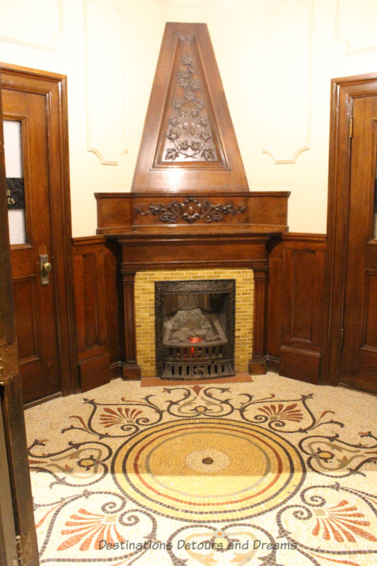 Corner fireplace framed in wood and tile floor from an old bank building