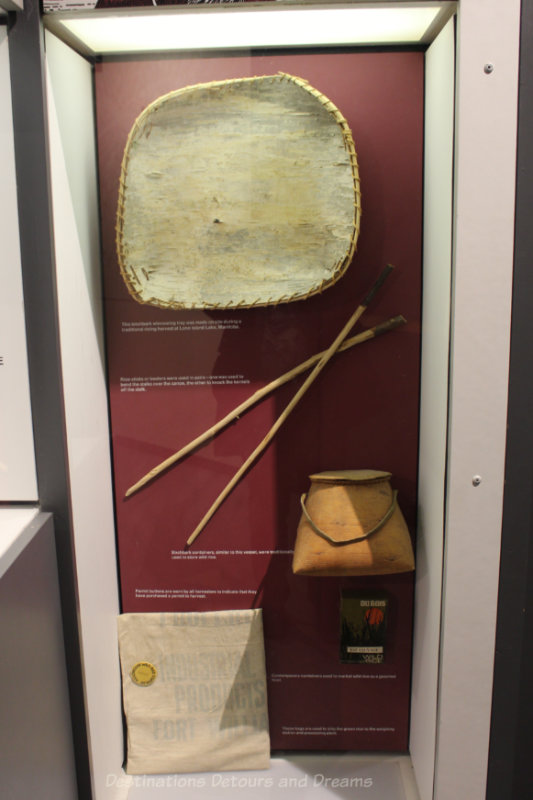 Display of tradition wild rice harvesting equipment - birchbark winnowing tray, rice-sticks, and birchbark containers