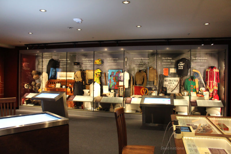 Long wall contain display cases of different themes in the Winnipeg Gallery at Manitoba Museum