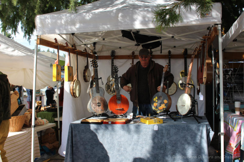 Collection of banjos and guitars for sale at Salt Spring Island Saturday Market