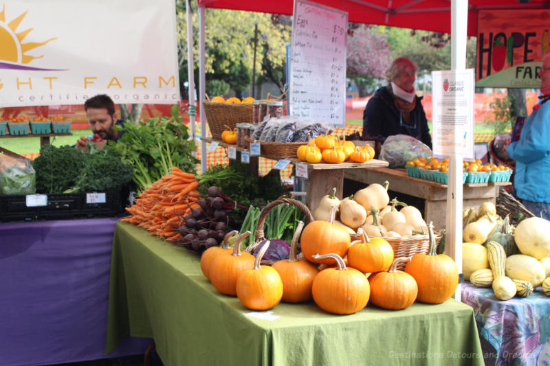 Vegetable stand containing pumpkin, squash carrots, and beets at Salt Spring Island Saturday Market