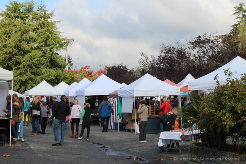 Visitors stroll among booths under tent canopies at the Salt Spring Island Saturday Market