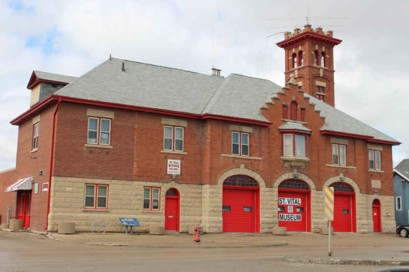 Old brick fire hall with red doors now housing a museum