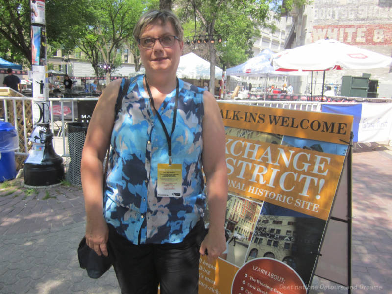 Standing beside a tour sign in a heritage district before embarking on a walking food tour