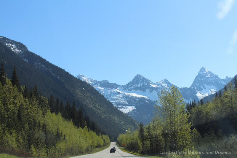 Highway through majestic snow-capped forested mountains