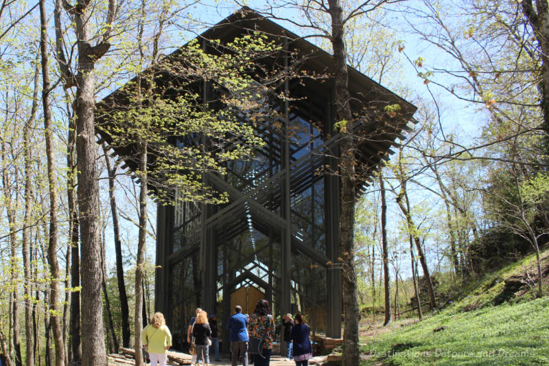 A tiny wood-framed, glass-walled chapel surrounded by trees