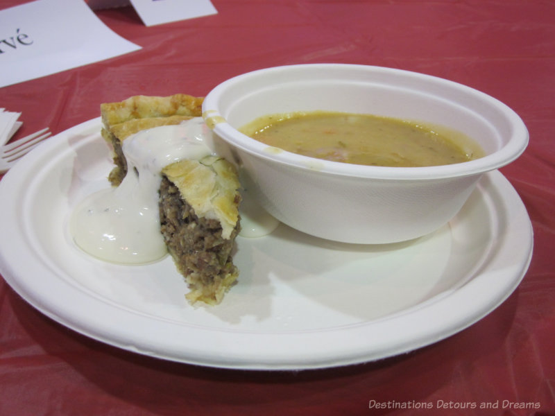 A plate containing a slice of tourtière (meat pie) and a bowl of pea soup