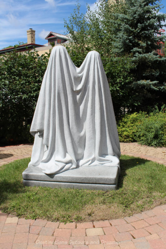 A sculpture showing two figures draped in white cloth