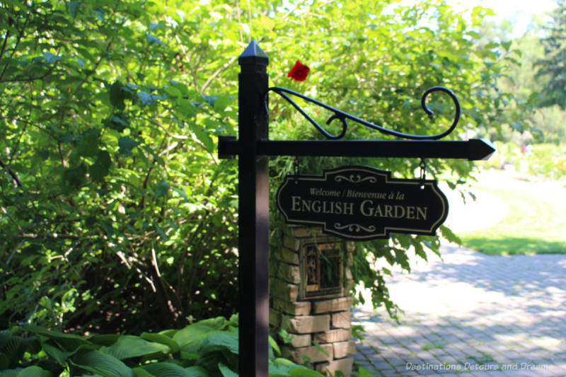 Signpost welcoming to English Garden in front of greenery