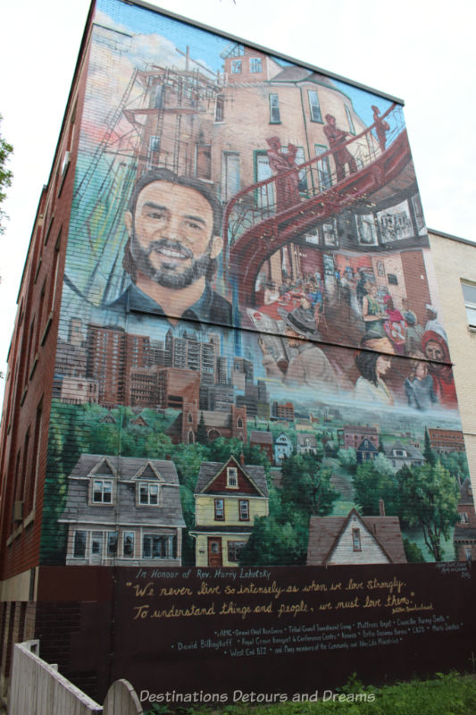 A mural containing a collage of items around the face of the many it commemorates such as housing in the city, food service