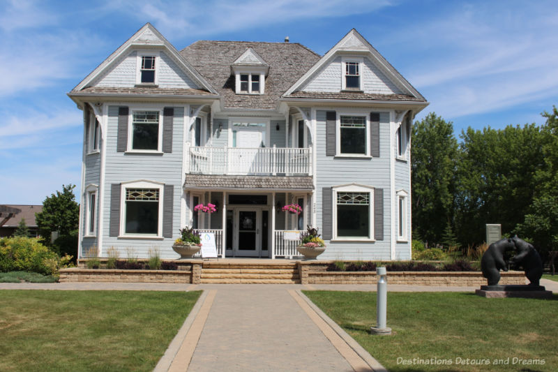 A two-and-a-half story wood-frame heritage home now used as an art gallery at Gallery in the Park in Altona, Manitoba