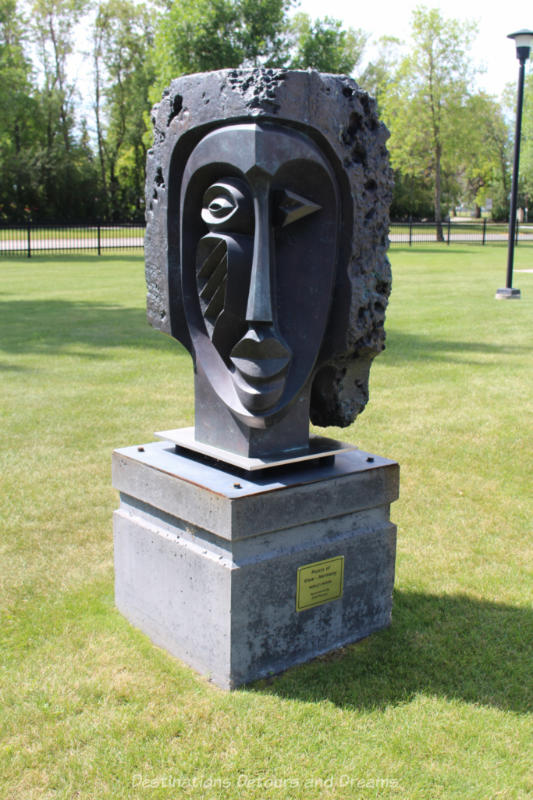 A sculpture in a park featuring a face with geometric facial features