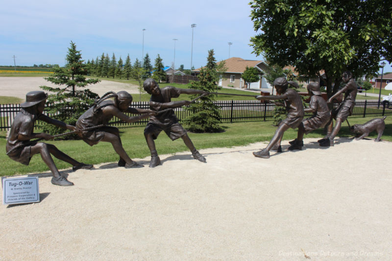 A sculpture of several figures pulling at opposite ends of a rope in a tug-of-war