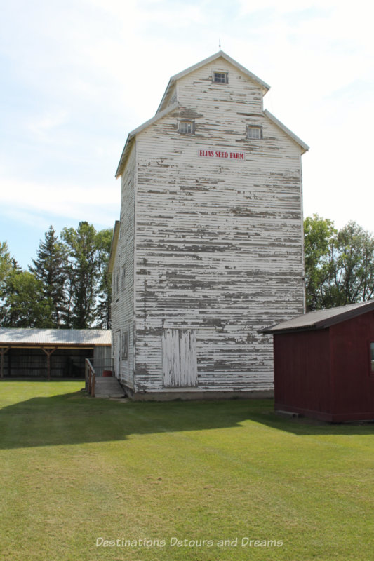 Weathered white wooden grain elevator at an outdoor museum