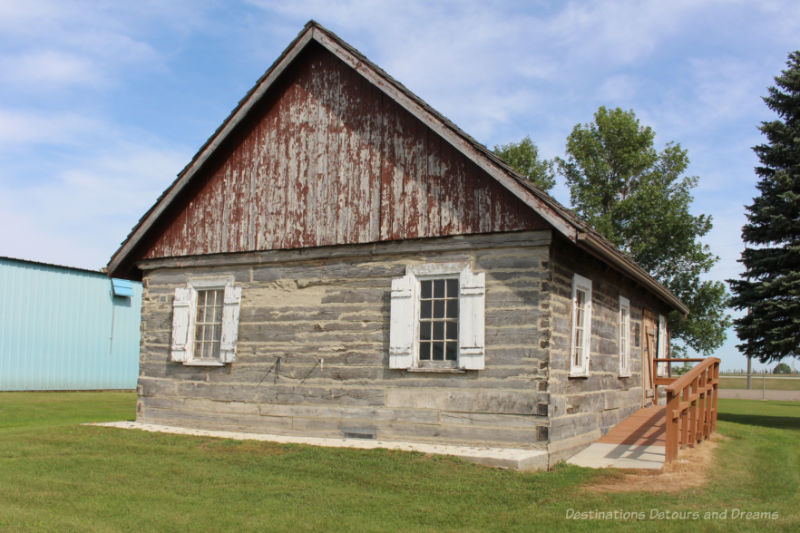 Weathered log house with ramp at side to entry door