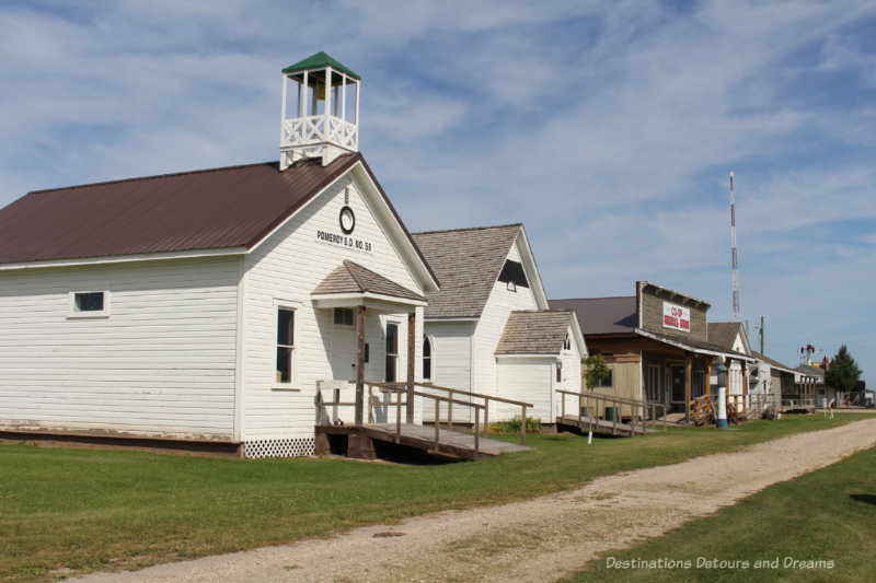 Museum heritage buildings in a row alongside a gravel path