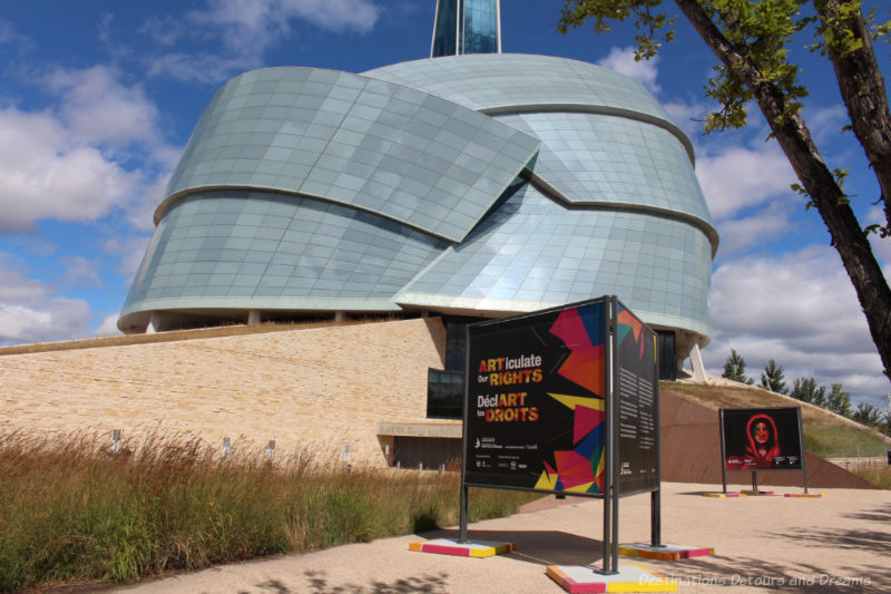 Billboard sign in front on the Canadian Museum for Human Rights building advertises the ARTiculate Our Rights exhibit 