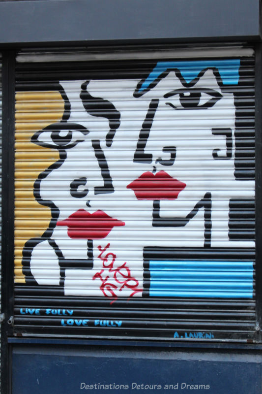 London street art in Shoreditch: Painted black outline of face with red lips