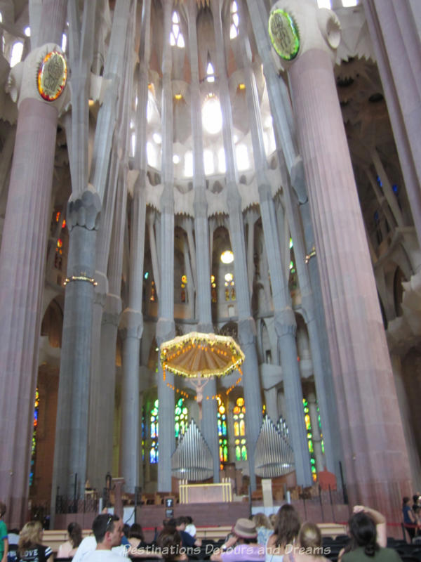 La Sagrada Família sanctuary amid tall stone pillars and light streaming through stained glass windows