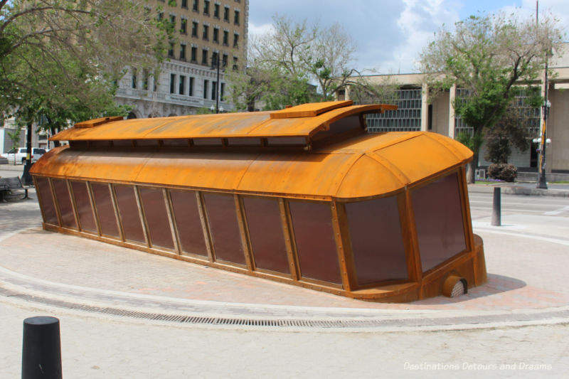 A public art piece in front on Winnipeg City Hall: a life-sized orange tilted trolley car