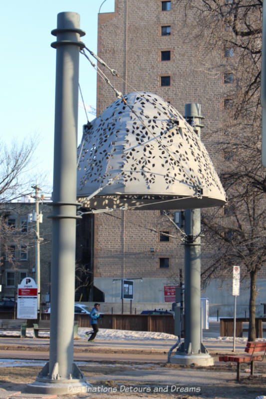 A Winnipeg public art piece featuring a bottomless dome with leave-shaped cutouts suspended at the top of two posts