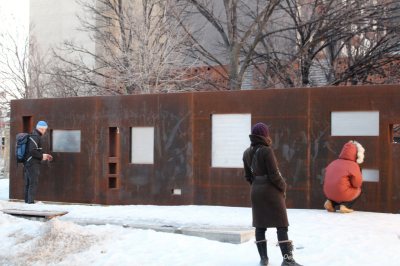 A Winnipeg public art piece consisting of wall of weathering steel with excerpts of text written on it 