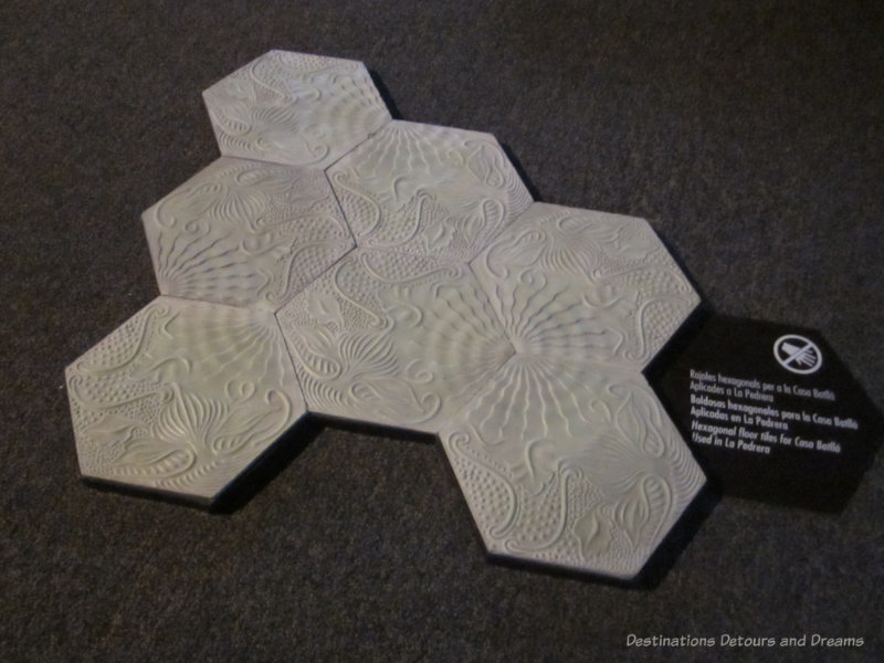 A display of white hexagonal floor tiles with designs in them 