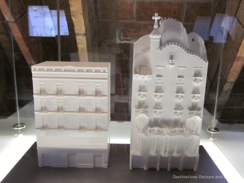 Two white models of multi-story Gaudí buildings