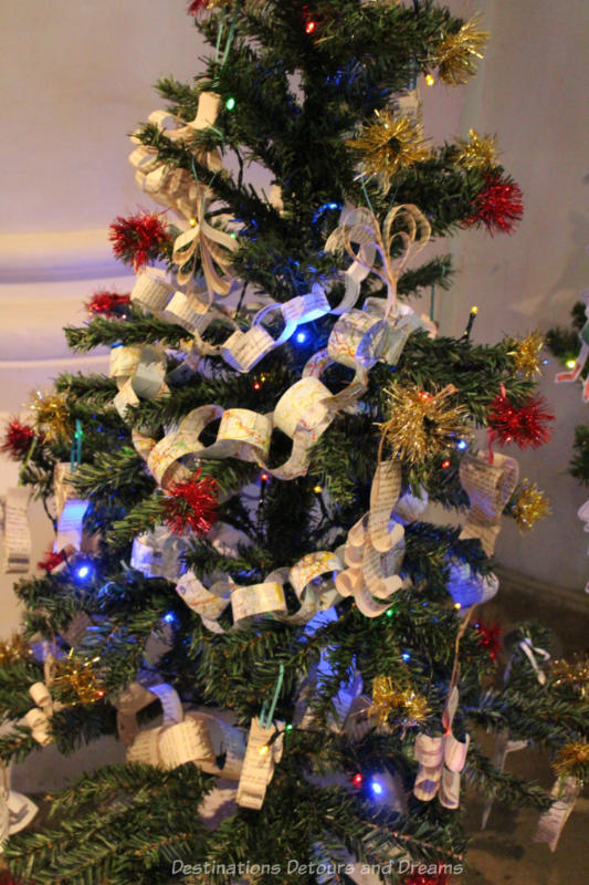 A Christmas tree decorated with paper chain garlands and red tinsel balls