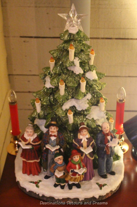 Ceramic Christmas tree with candle lights and carols in front of it