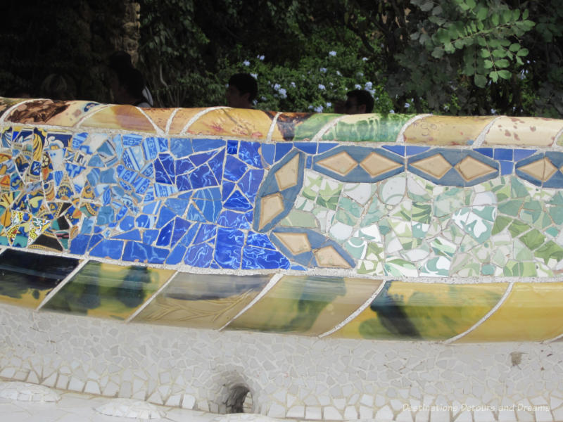 Stone bench with colourful tile mosaics on its back at Park Güell