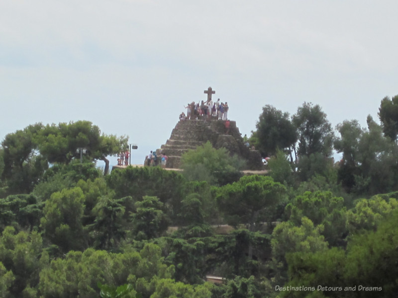 A cross monument atop a hill at Park Guell