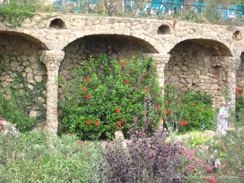 Flowers and foliage against a stone wall at Park Güell