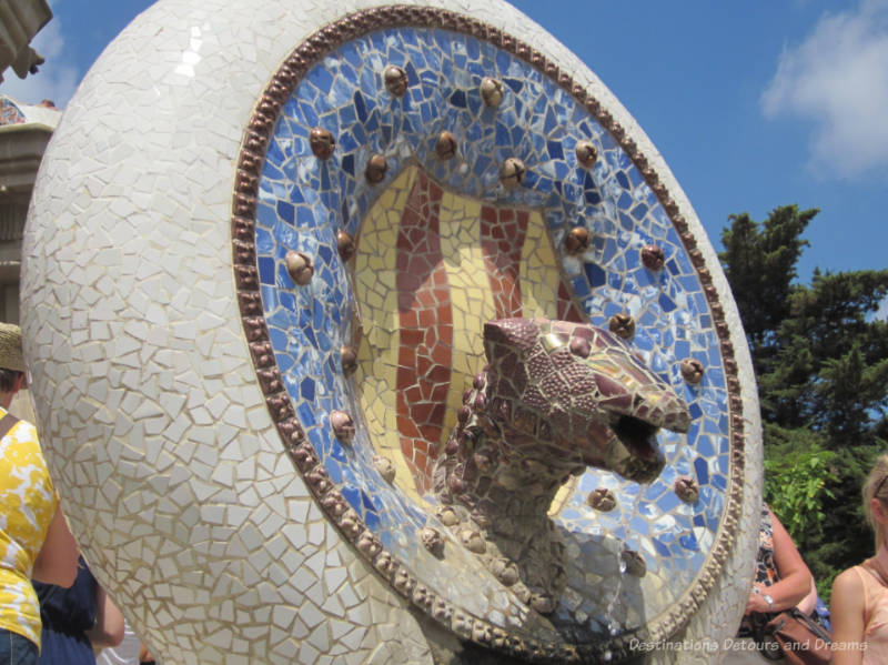 Mosaic tile head in a circle on stairway at Park Güell