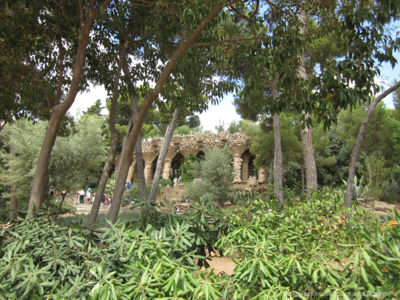 Vegetation and trees with columns of rough-hewn stone in the background