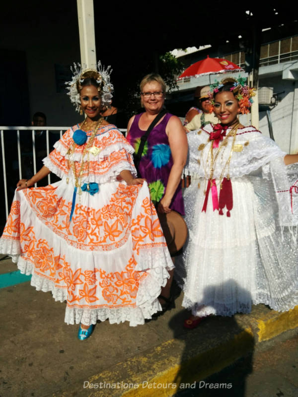 Blog author with two women clad in traditional Panamanian polleras at the Thousand Polleras Parade