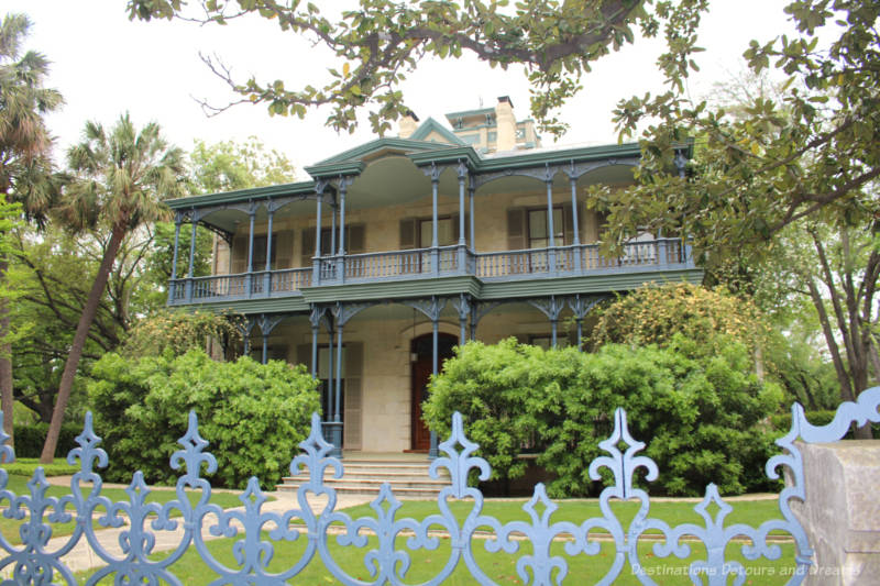 Two-story heritage home with cast iron porch and fence decorations