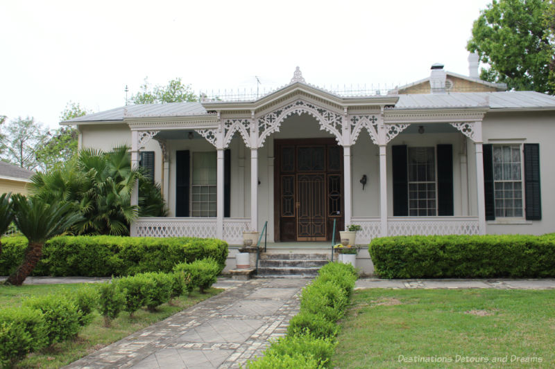 Heritage home in San Antonio King William District with intricate front veranda latticework detailing