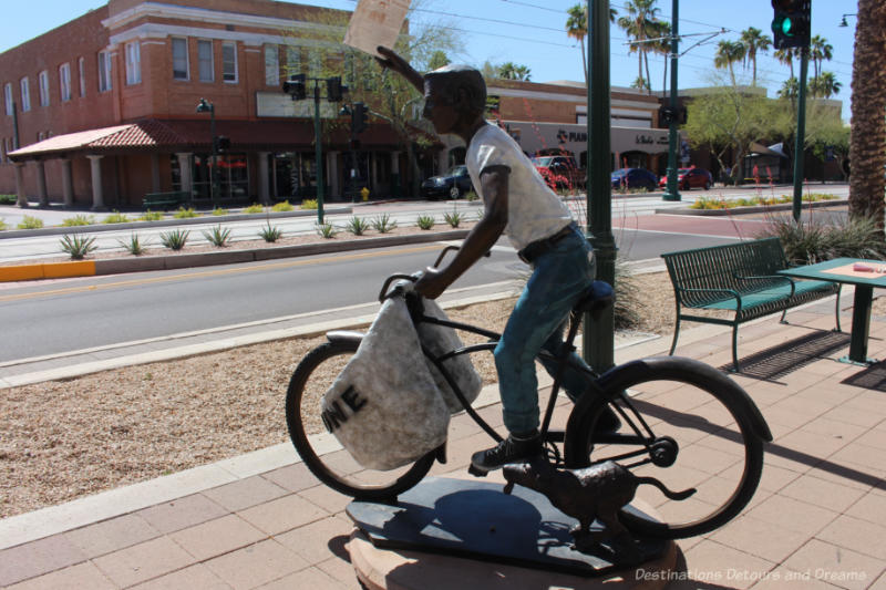 Sculpture of a newspaper delivery boy on a bicycle