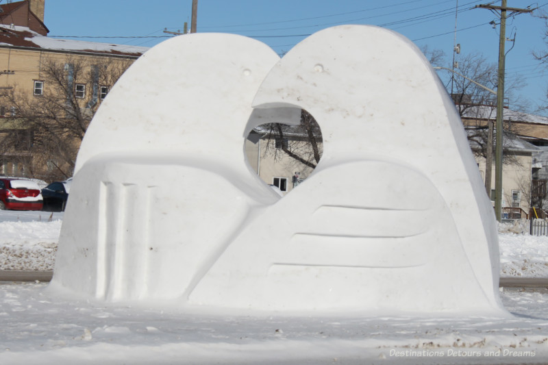 Snow sculpture of two stylized birds beak to beak