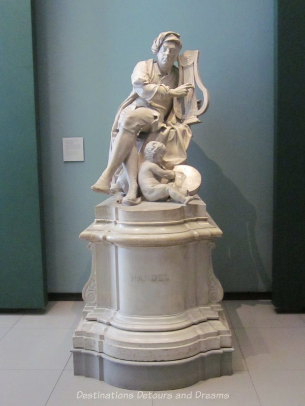 Marble sculpture of Handel playing lyre while a cherub at his feet transcribes