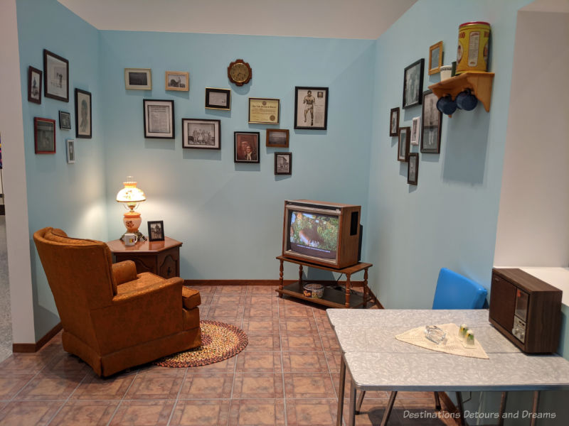 Recreation of a 1970s era living space with easy chair, television, chrome table at an Inuit art exhibit